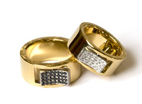 Zwei goldene Hochzeitsringe mit silberner Ecke liegen übereinander